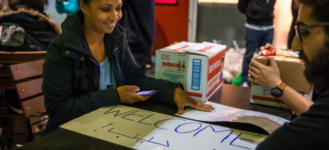 Freiwillige empfangen ankommende Flüchtlinge